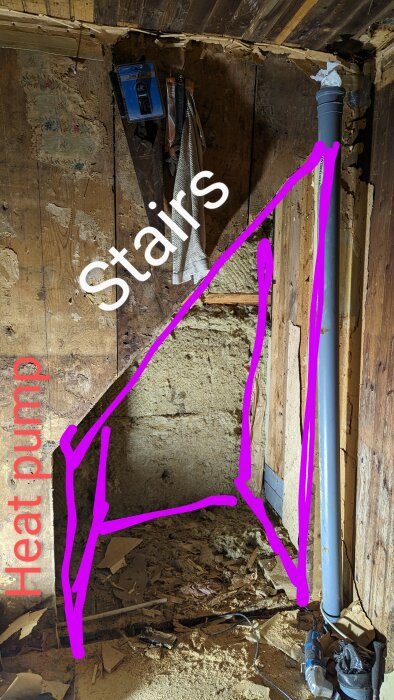 Nedgång till trappor, värmepumpsledningar, rör, källarutrymme, renoveringsarbete, synlig isolering, träväggar, skräp på golvet.