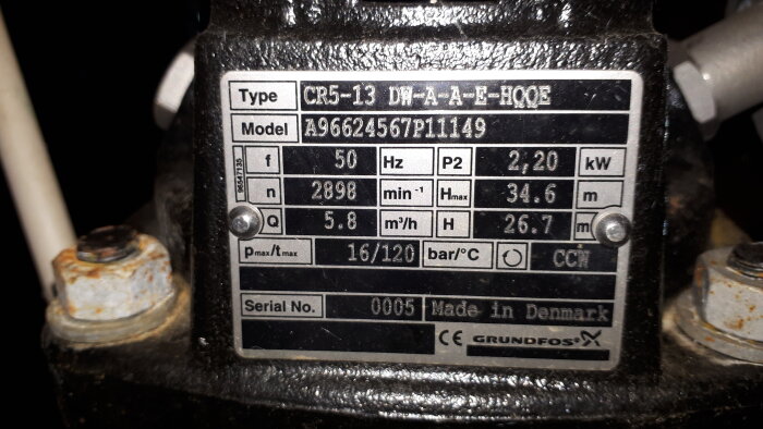 Typskylt på pumpekipering. Grundfos varumärke. Tekniska specifikationer: frekvens, flöde, effekt. Tillverkad i Danmark. Serienummer 0005.