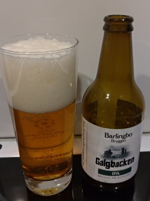 Ölglas med skum, tom ölflaska, Barlingbo Bryggeri, Galgbacken IPA, bryggt på Gotland.