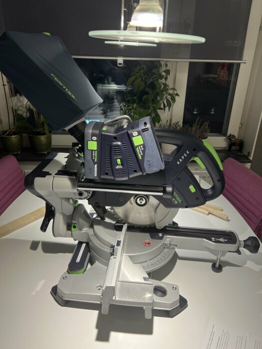 Geringssåg från Festool (modell Kapex) på bord med bakgrund av fönster och växter.