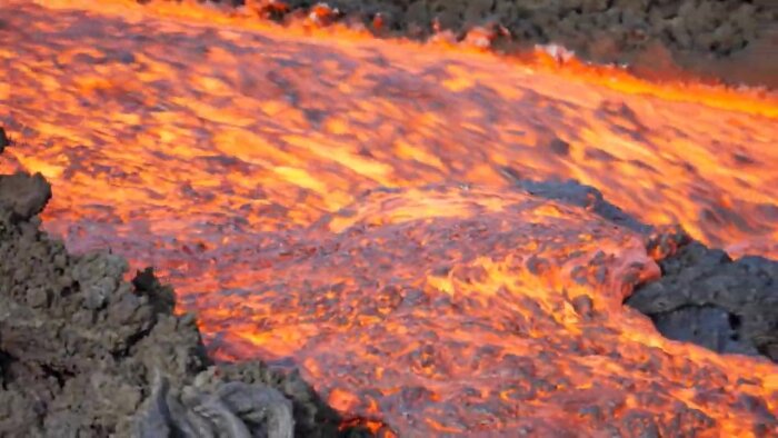 Flytande lava strömmar, glödande röd-orange, vulkanisk aktivitet, naturkraft, geologisk fenomen.