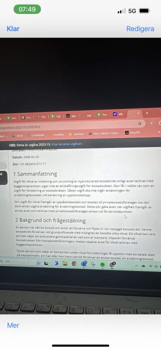 Laptop skärm visar textdokument, gränssnitt för webbläsare, svensk text om bostadsrätt, delvis suddig bild.