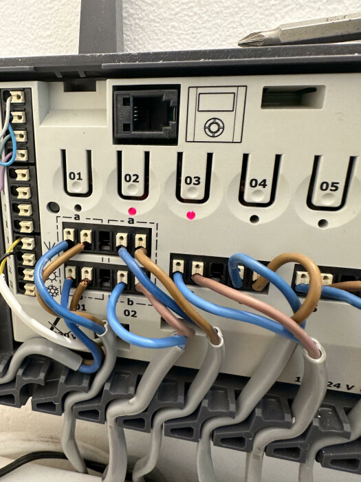 Ett öppet elektriskt kopplingsskåp med synliga kablar och anslutningar, saknar sitt lock.