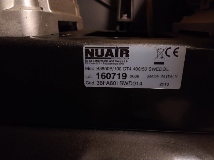 Etikett på svart yta, "NUAIR" kompressor, modell, tillverkningsinformation, "Made in Italy", 2013.