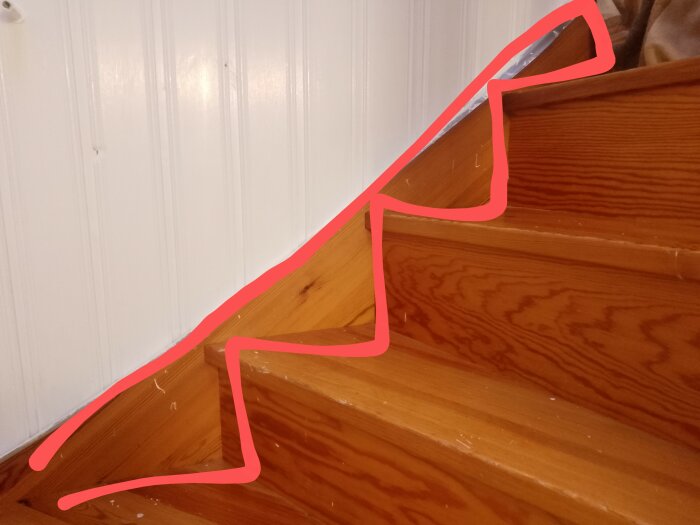 Trätrappa med ljusa väggar och rosa linje markerar imaginär stigningslinje eller ledstång.