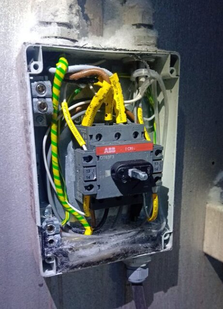 Ett öppet elektriskt kopplingsskåp med ledningar och en ABB strömbrytare, installeras eller repareras.