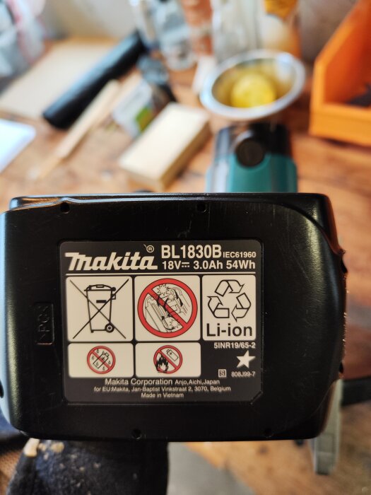 Makita batteri, varningsetiketter, återvinningssymboler, Li-ion, 18V, 3.0Ah, otydlig bakgrund, verktygsarbete, tillverkat i Vietnam.