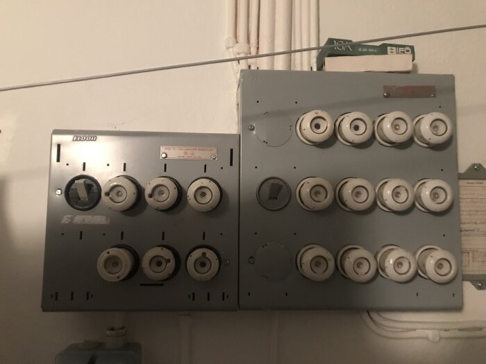 Äldre säkerhetssystem eller el-central med säkringar och mätinstrument på vägg, analog, teknik, installationsutrustning.