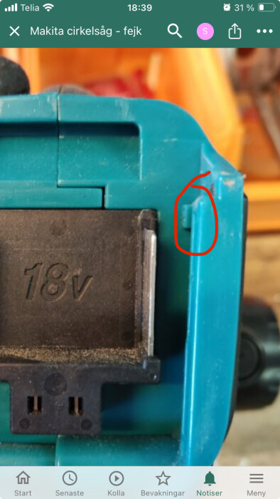 Närbild, blå Makita verktyg, "18V" märkt, skärmbild telefon, ikoner under, röd markering.