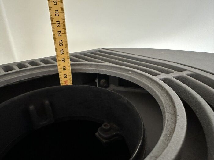 Måttband mäter höjden på högtalarelement, strukturerad yta, teknisk kontext, ingen bakgrundsföremål.