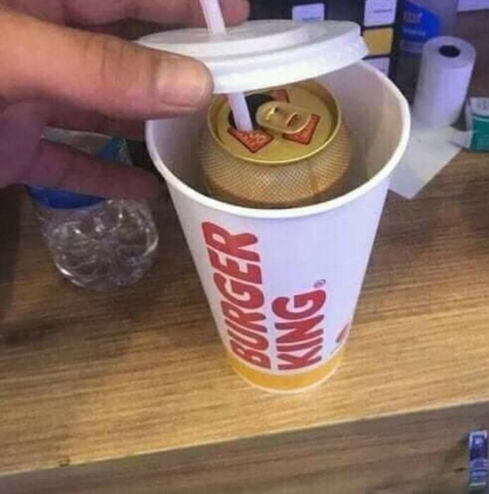 En Burger King-mugg med burköl dold under lock och sugrör.