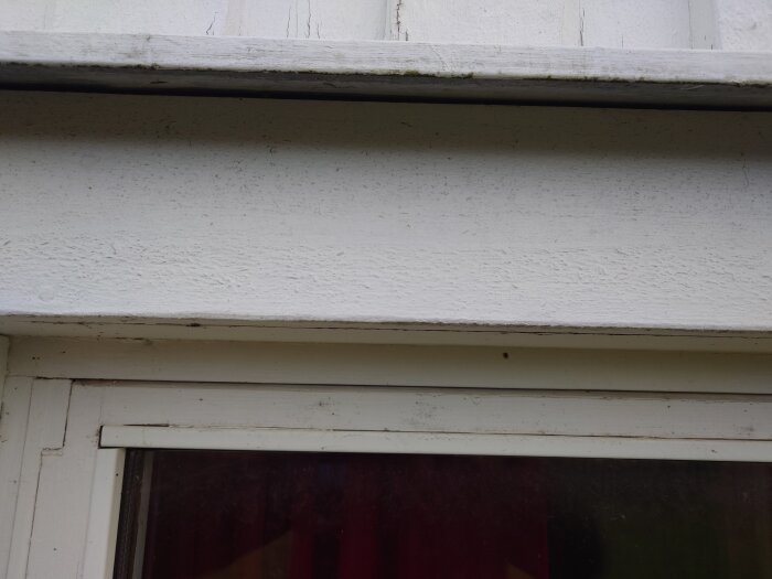 Vit vägg och fönsterkarm, behöver rengöring, yttre byggnadsdetaljer, slitet, enkelt.