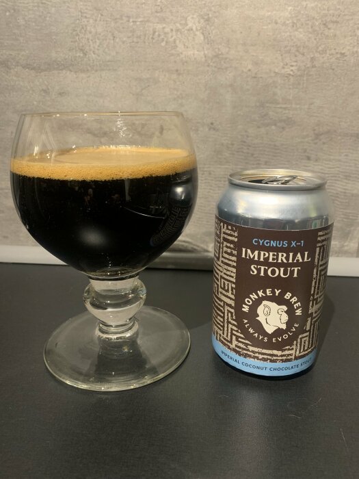Ett glas mörkt öl och en ölburk med text "Imperial Stout" på en bänkskiva.