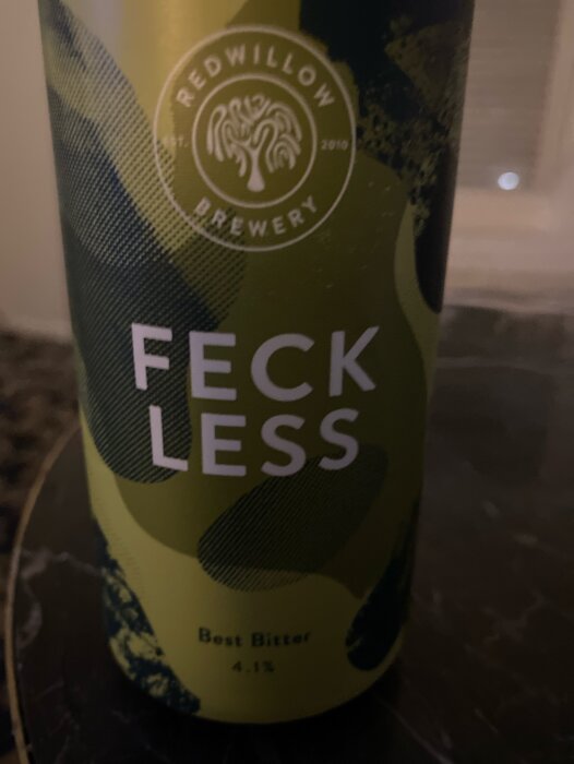 Ölburk från Redwillow Brewery, "Feckless" Best Bitter, 4.1%, gröna och svarta nyanser, delvis suddig bakgrund.