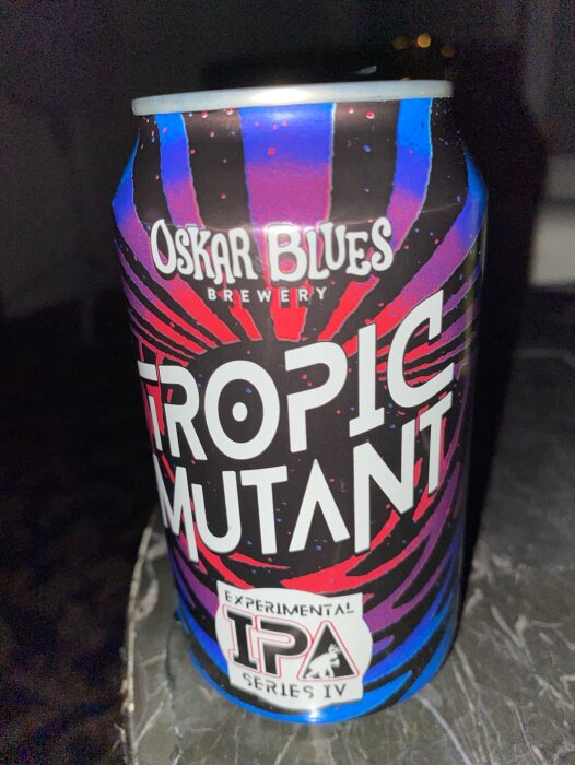 En ölburk märkt "Oskar Blues Brewery TROPIC MUTANT, Experimental IPA Series IV" med färgstark design.