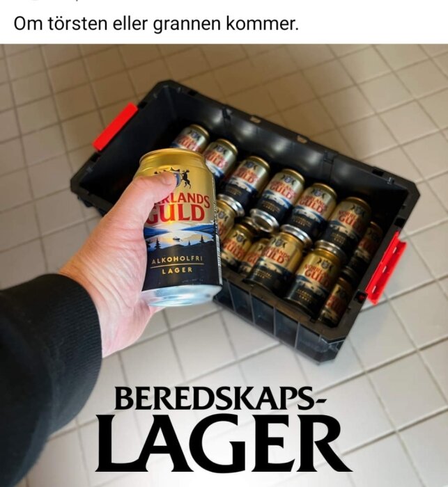 Hand håller alkoholfri ölburk, låda med fler ölburkar, text "beredskapslager", humoristisk referens till törst eller grannbesök.