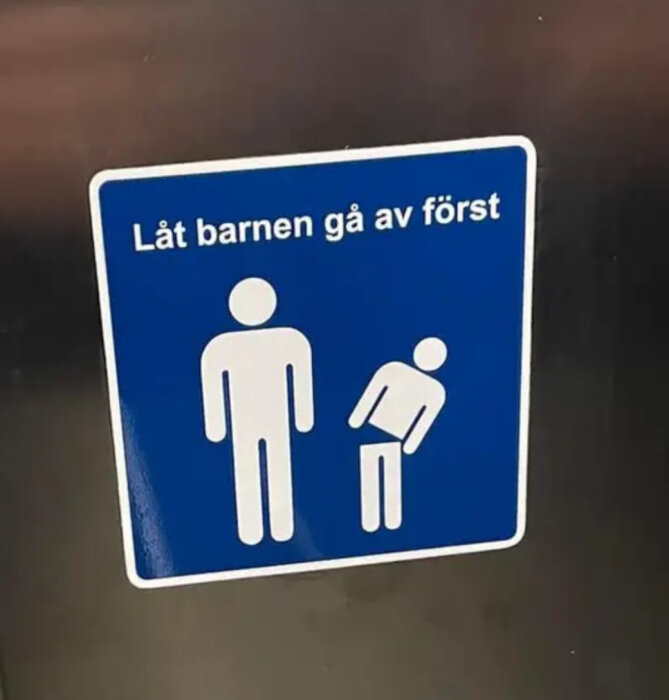 Blå skylt, ikoner av en vuxen och ett barn, text "Låt barnen gå av först".