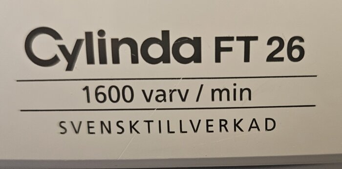 Etikett för "Cylinda FT 26", 1600 varv per minut, "svensktillverkad". Vit bakgrund, svart text.