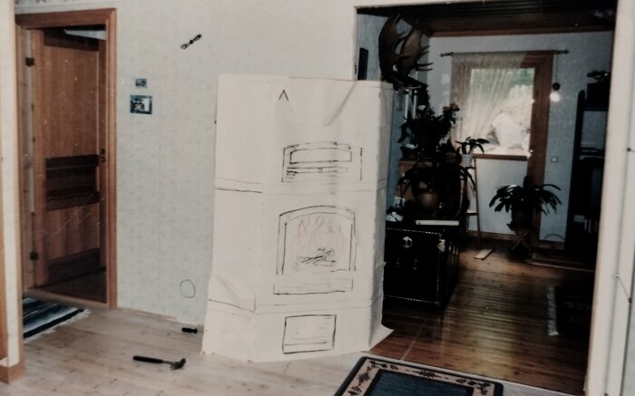 Ett ritat kylskåp på papp i ett vardagsrum, gammalt foto, trägolv, inomhusmiljö, konstnärligt uttryck, hemtrevlig känsla.