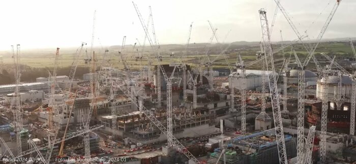 Stort byggarbetsområde, många kranar, industriell konstruktion, byggplats, landlig bakgrund, komplex infrastruktur.