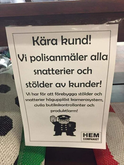 Svensk skylt som informerar om polisanmälan vid stöld, högupplösta kameror och butikskontrollanter, med polisemblemet.