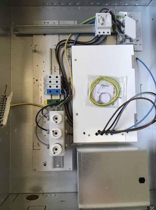 Elektrisk apparatskåp med kablage, kopplingsutrustning, och överblivna installationskomponenter.