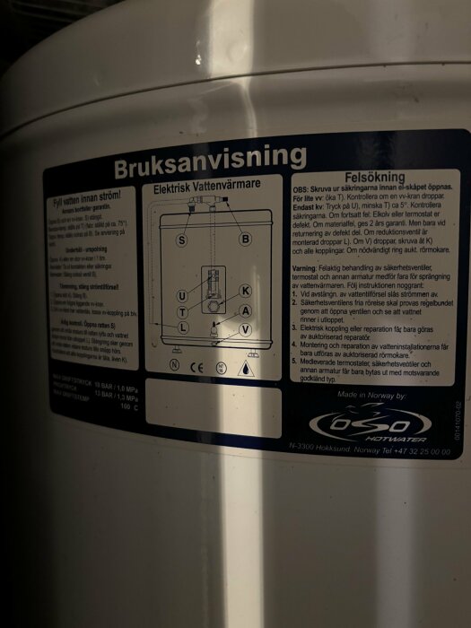 Instruktionsdekal för elektrisk vattenvärmare med bruksanvisning, felsökning och säkerhetsinformation.