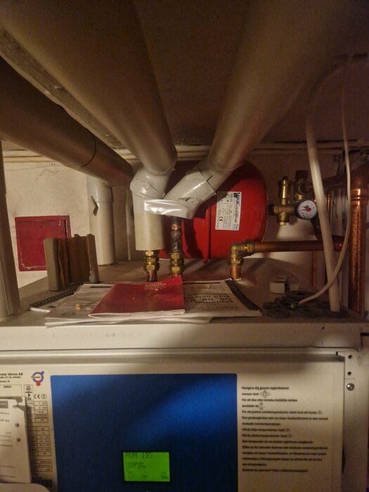 Värmeväxlare, rör, teknisk utrustning, installationsmanualer, post-it med temperaturanteckning.