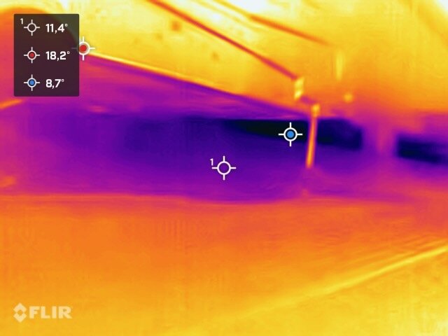 Värmekamerabild som visar temperaturskillnader, troligtvis av en byggnadsdel, med temperaturmätningar i Celsius.