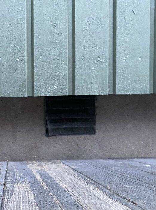 Träpanelvägg och golv med ventilationsskydd. Grå, sliten textur. Nordisk stil. Inomhus eller utomhus, minimalistisk.