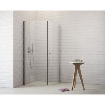 Modernt duschhörn med glasdörrar, vit kaklad vägg, träpall och handdukar på golvet.