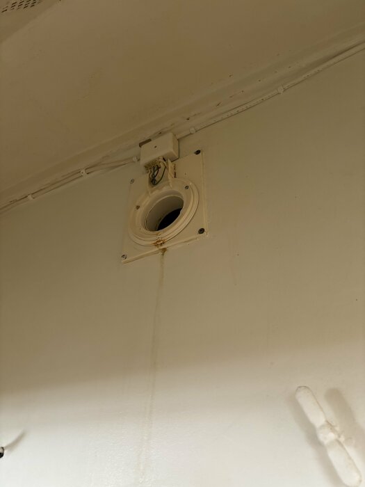 Öppet ventilationshål i tak, synliga kablar, smutsfläckar, spår efter vattenläckage.