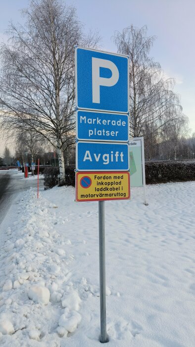 Parkeringskyltar i snöigt landskap som anger avgiftsbelagda markerade platser med motorvärmare användningsregel.