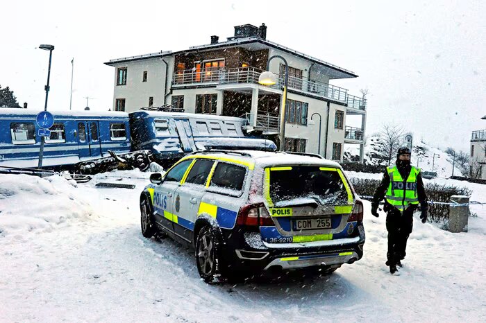 Vinterolycka: Polisbil, snö, tågurpspårning, polis på plats, olycksområde.