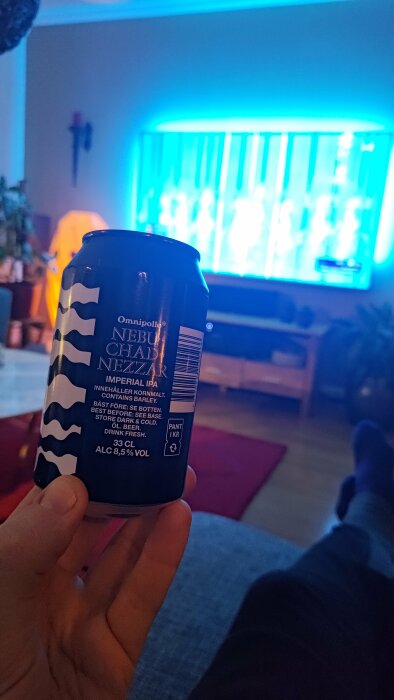 Ölburk i förgrunden, suddig tv i bakgrunden, inomhusmiljö, person avkopplande, blått ljus.