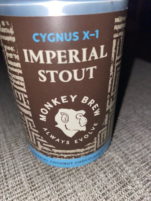 Ölburk med texten "CYGNUS X-1 IMPERIAL STOUT", apans bild, "MONKEY BREW ALWAYS EVOLVE", "IMPERIAL COCONUT CHOCOLATE".