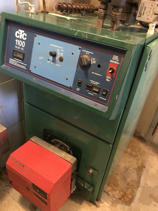 CTC 1100 olje-el panna med kontrollpanel och röd expansionskärl i pannrum.