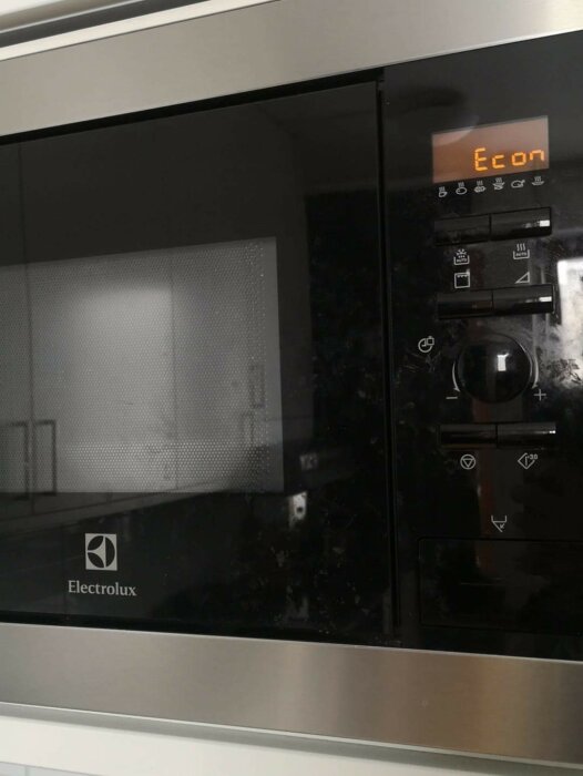 Inbyggd mikrovågsugn från Electrolux med svart front, orange display och kontrollknappar, visar ordet "Econ".