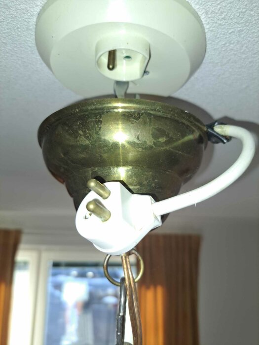 Taklampa med metallarmatur, sladd, stickkontakt omvandlad till takuttag. Monteringsfel, osäker elinstallation.