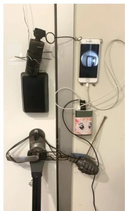 Väggmonterad laddningsstation med improviserade hållare för två telefoner och en powerbank.