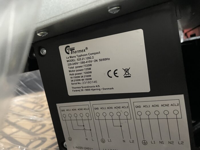 Etikett på elektronisk enhet visar modell, strömkrav och kopplingsschema, märkt Thermex, industriell bakgrund.