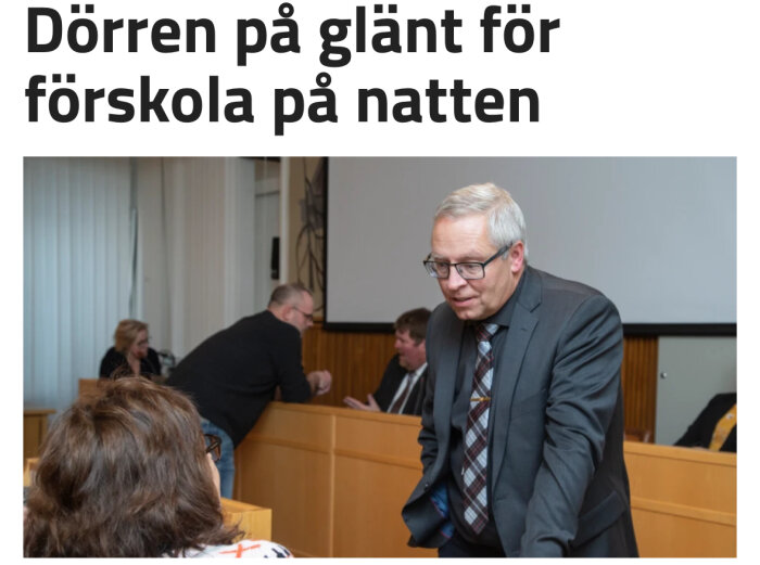 Man i kostym pratar, personer i mötesrum, rubrik hänvisar till förskola.