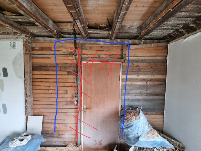 Renoveringsrum med avskalade väggar, synliga takbjälkar och en dörr, teckning överlagrad.