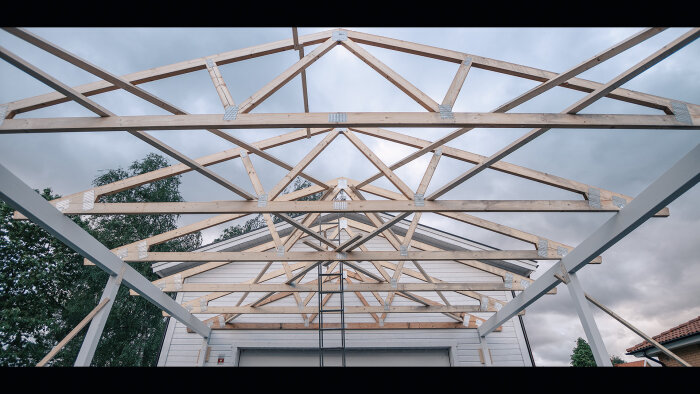 Trästomme under konstruktion, grå himmel, metallbeslag, byggnad i bakgrunden, modern arkitektur, obehandlat virke.