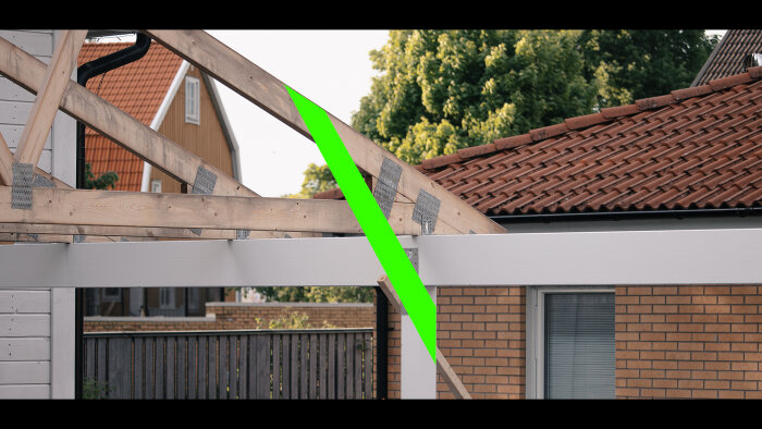 Takstolar under konstruktion, tegeltak i bakgrunden, träkonstruktion framför, grön digital linje genom bilden.