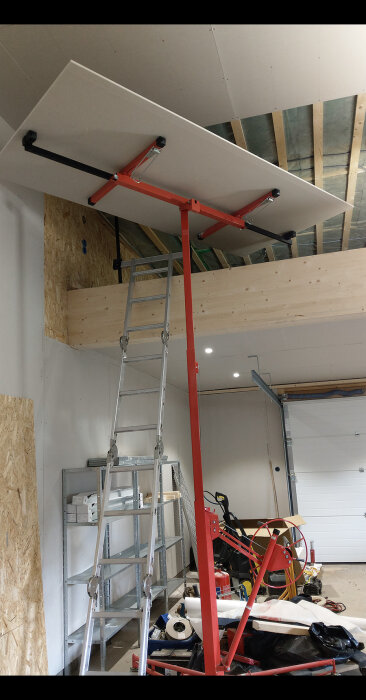 Inomhusbyggarbetsplats, gipsvägg hiss, stege, OSB, oordning av verktyg och material, ofärdig konstruktion.