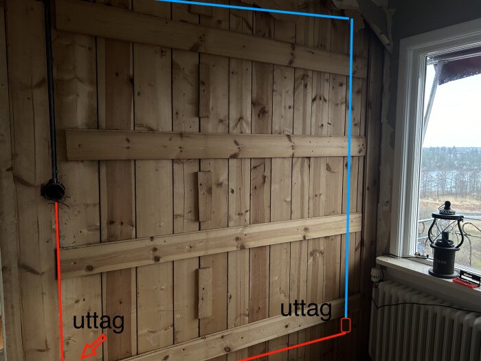 Träräcke med markerade uttag, rör och ett fönster med utsikt, inomhusrenovering pågår.