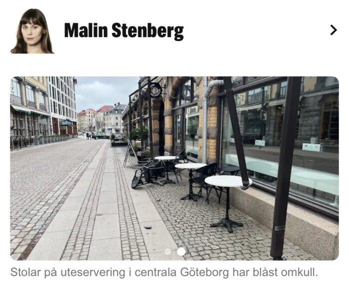 Uteservering med omkullblåsta stolar på gata, molnig dag, ingen person synlig, storstadsmiljö.