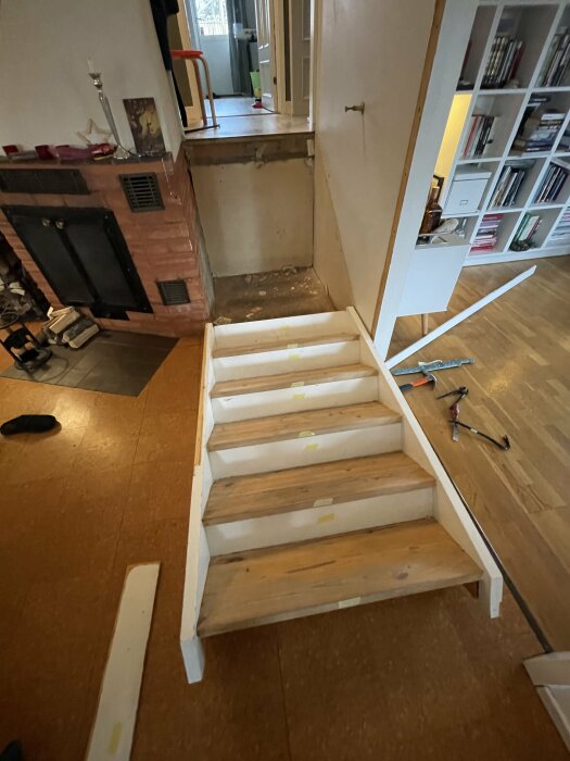 Renovering av trappsteg inne i ett hem, verktyg och byggmaterial synliga.