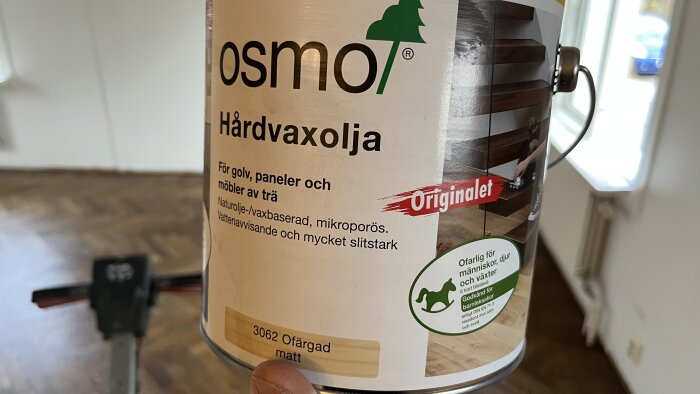 Burk med hårdvaxolja, märke Osmo, för trägolv och möbler. Ofarlig, vattenavvisande. Inomhusmiljö suddig bakgrund.